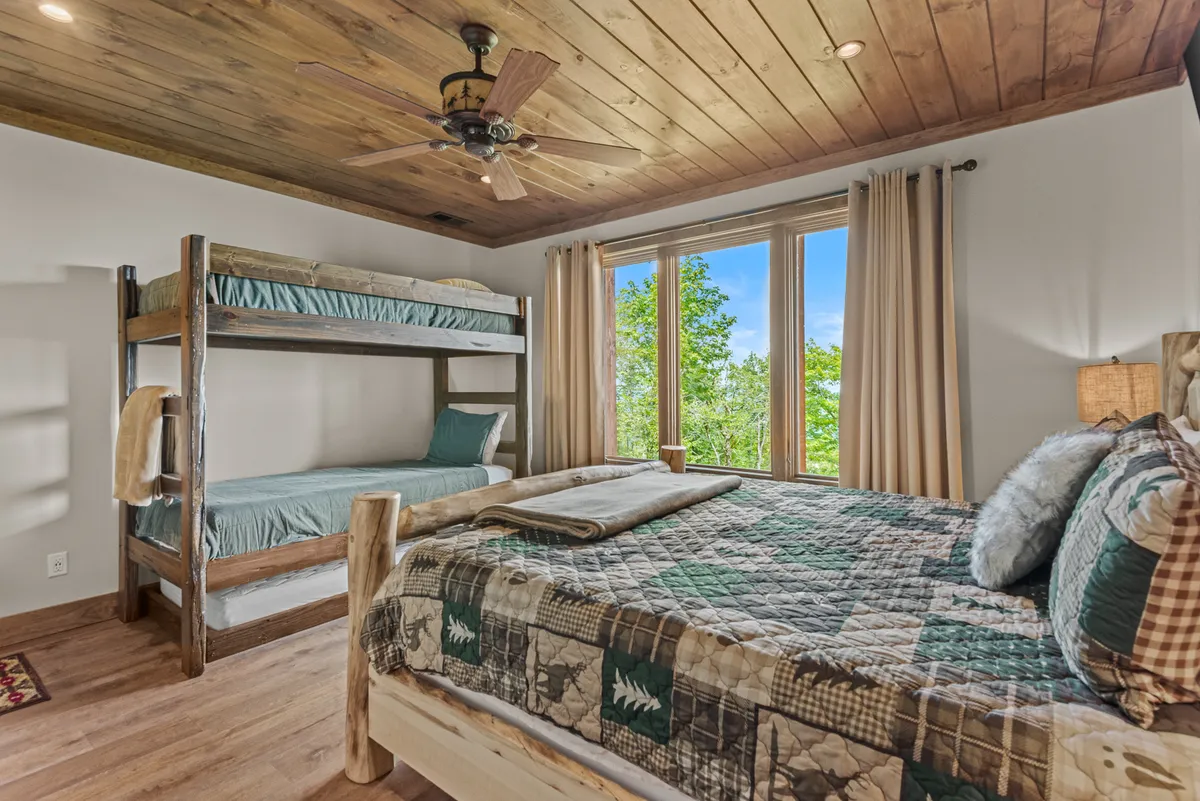 A flexible family suite combining a queen bed and a cozy bunk bed, with large windows offering calming views. The room is bright, welcoming, and ideal for multi-generational stays or accommodating families with children.